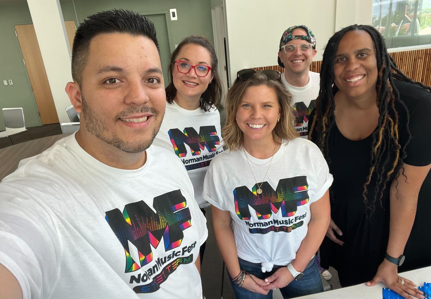 Two men and three women posing in Norman Music Fest Street Team shirts